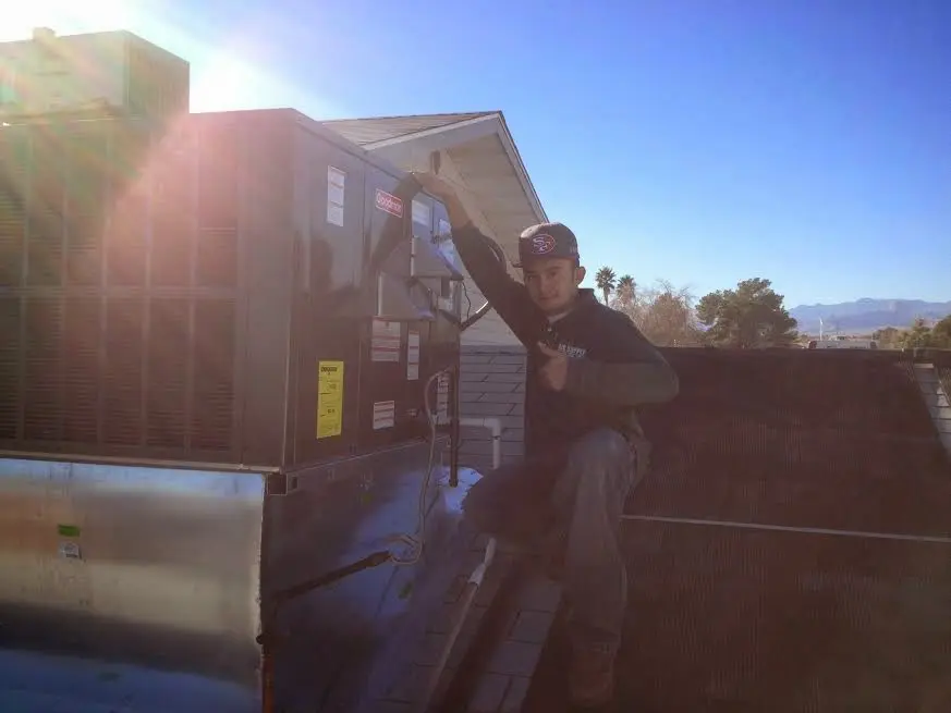 HVAC technician performing Boiler Repair on a rooftop unit in Crandall
